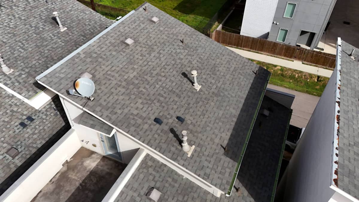 Completed shingle roof replacement across a multi-unit residential building in Houston’s East End