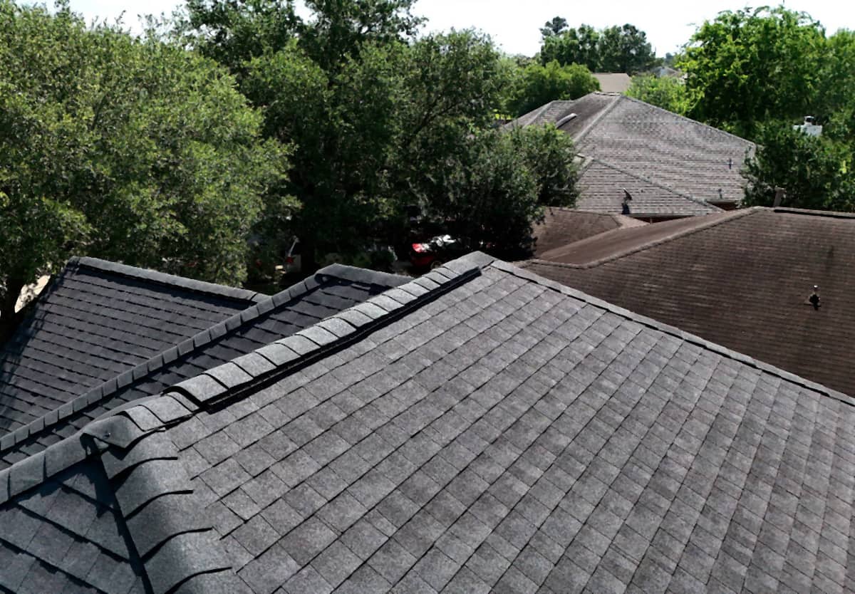 Close view of new hip and ridge caps running along a finished gray shingle roof in Katy, TX