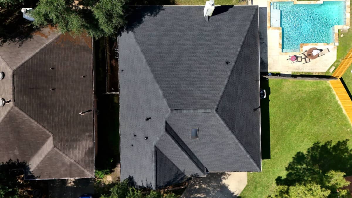 Top-down drone view of a completed charcoal shingle roof replacement on a Katy, TX home