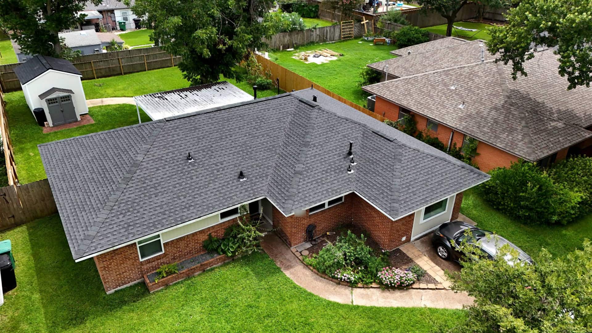 Rear view of a completed shingle roof replacement on an Oak Forest, Houston home