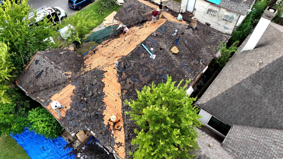 Drone view of a Riverside, Houston roof mid tear-off, with old shingles stripped to the deck