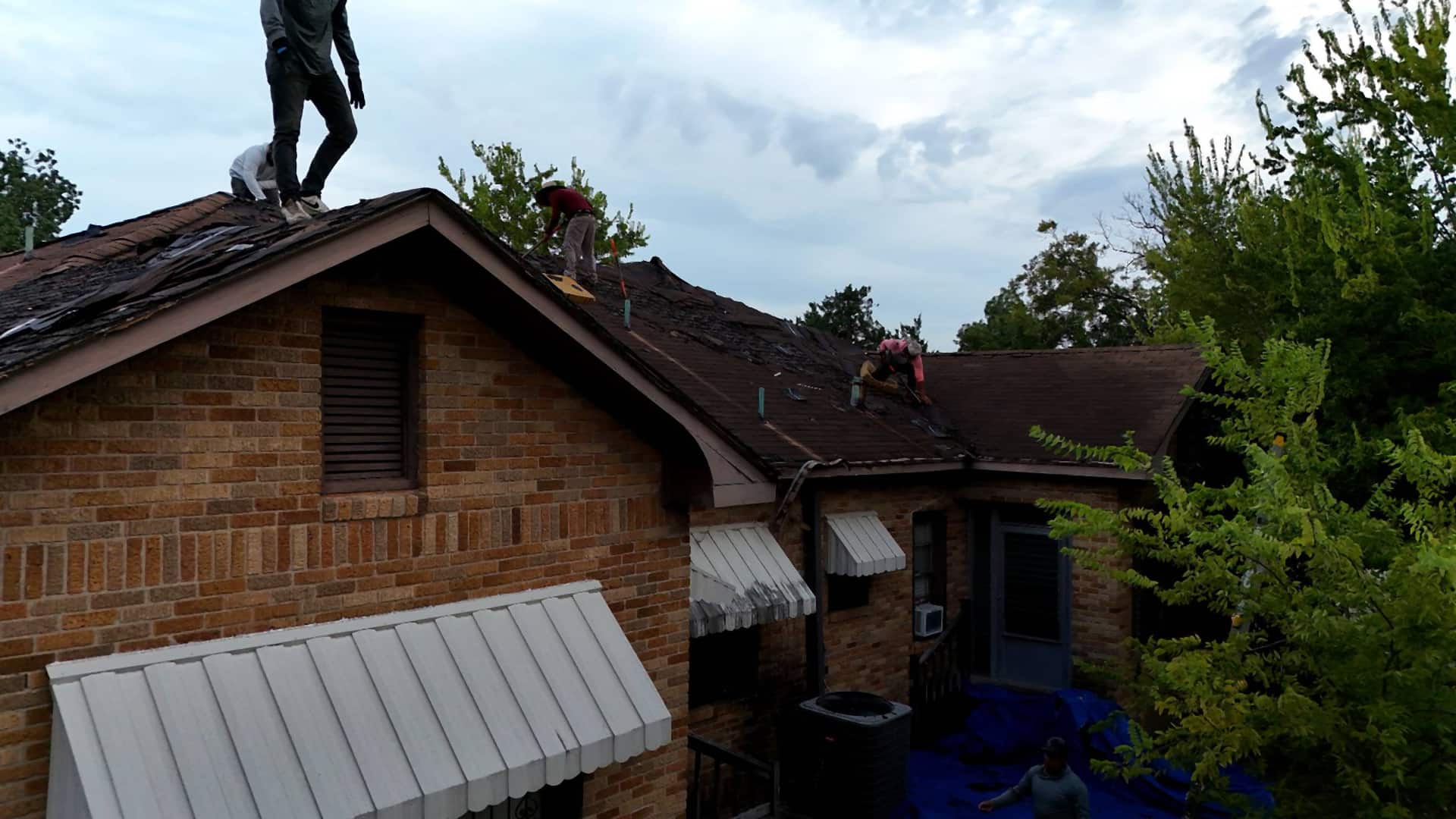 Handy Hands crew tearing off old shingles on a Riverside, Houston roof