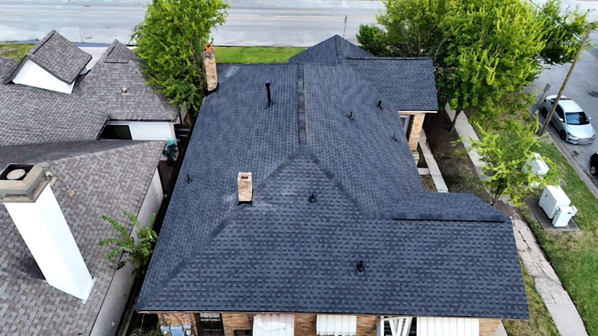 Top-down drone view of the finished shingle roof replacement on a Riverside, Houston home