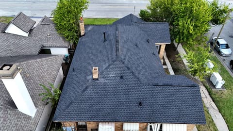 Top-down drone view of the finished shingle roof replacement on a Riverside, Houston home