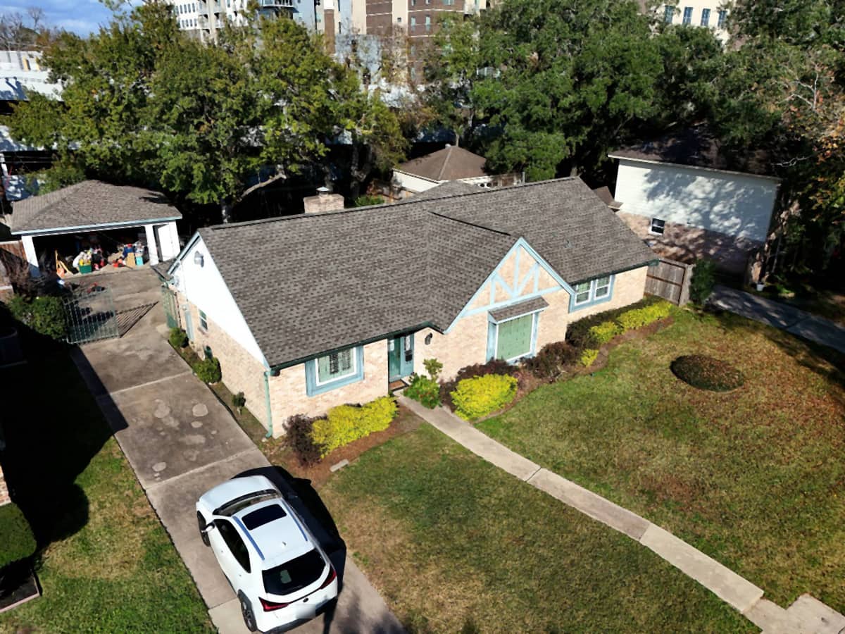 Elevated view of a Spring Branch, Houston home with a newly installed brown shingle roof and teal trim