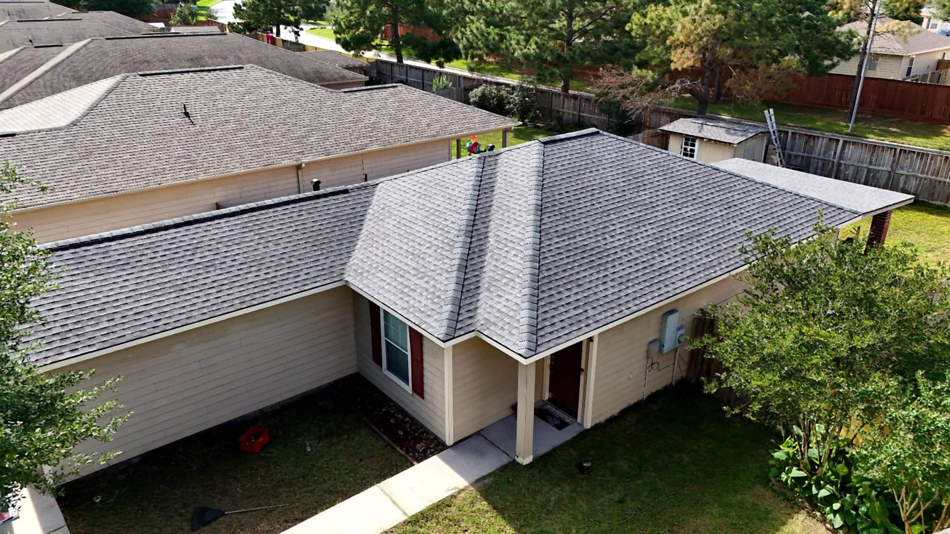 Aerial oblique view of a clean gray hip roof replacement on a Spring, TX home