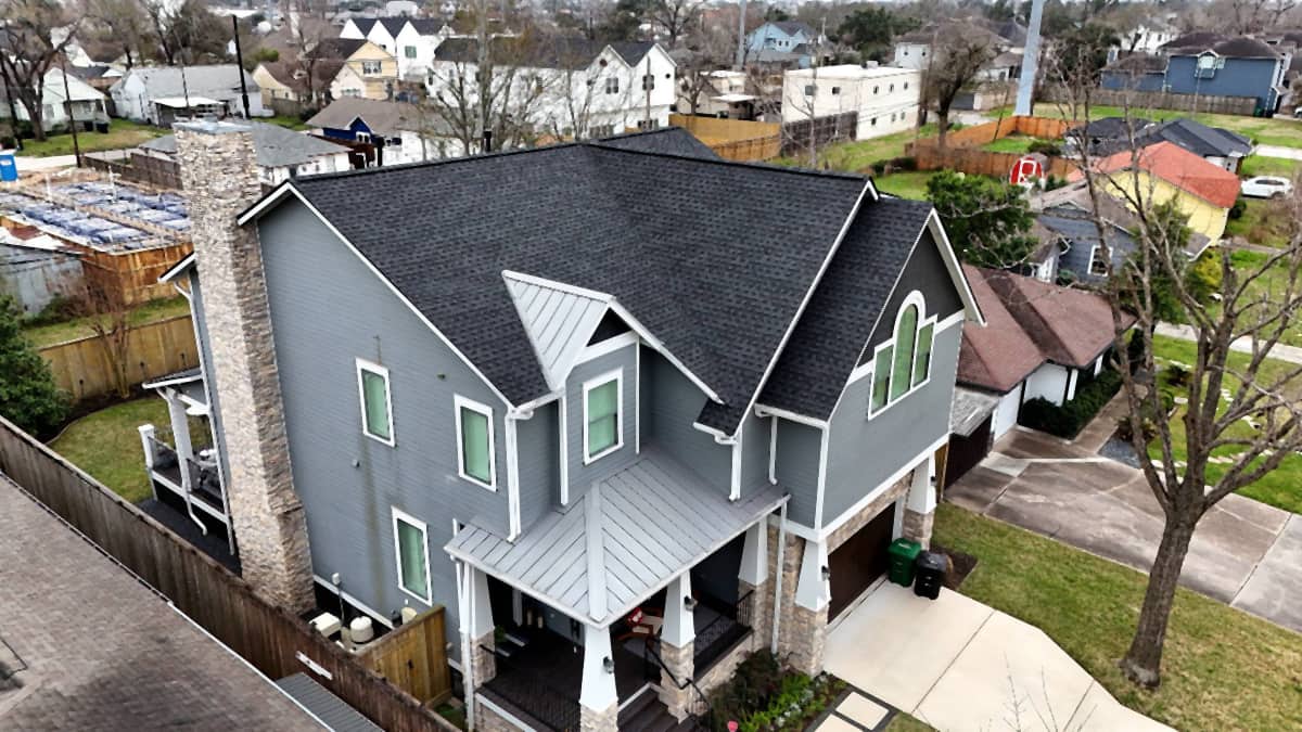 Modern two-story home in The Heights, Houston with a completed dark charcoal shingle roof and standing-seam metal porch accents